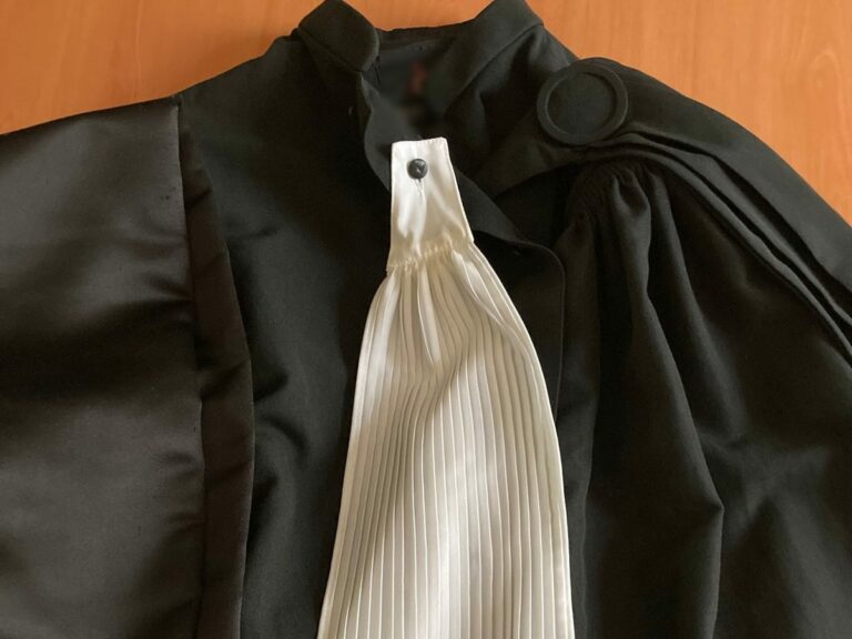 Robe d'avocat et rabat posés sur un bureau